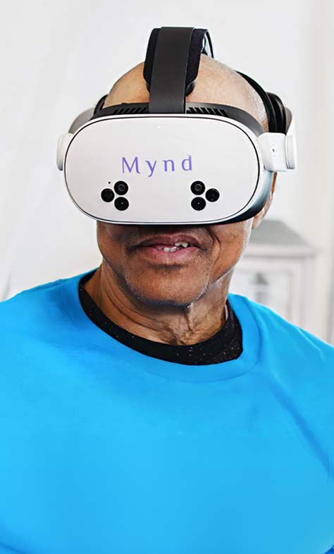 Smiling man wearing white virtual reality headset, appearing engaged.