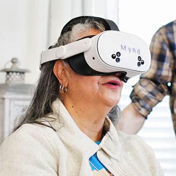 Elderly woman wearing a white VR headset.