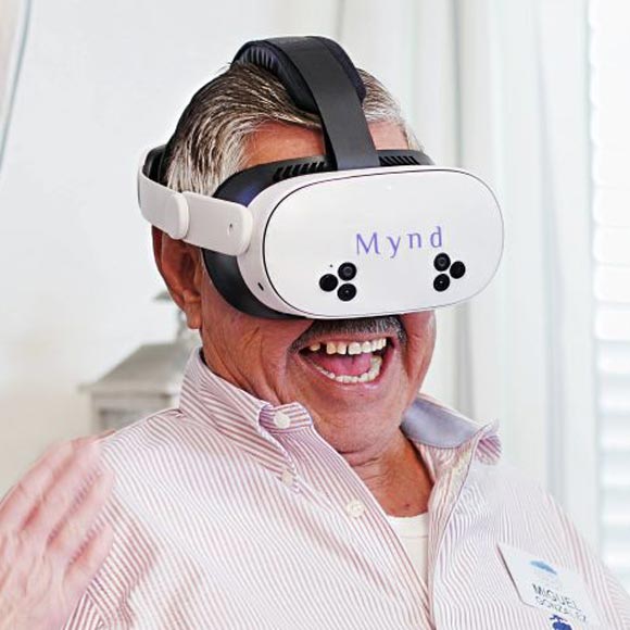 Elderly man wearing a white VR headset.