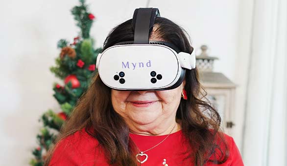 Elderly woman wearing a white VR headset.